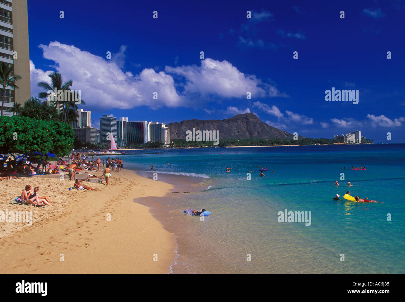 Menschen Touristen Sonnenanbeter Sonnenbaden schwimmen Waikiki Beach mit Diamond Head im Hintergrund Insel Oahu Hawaii hotels Stockfoto