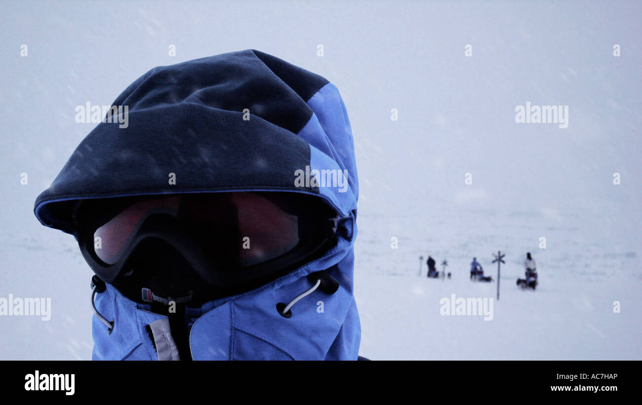 Ein Polarforscher mit Huskys im Hintergrund Stockfoto