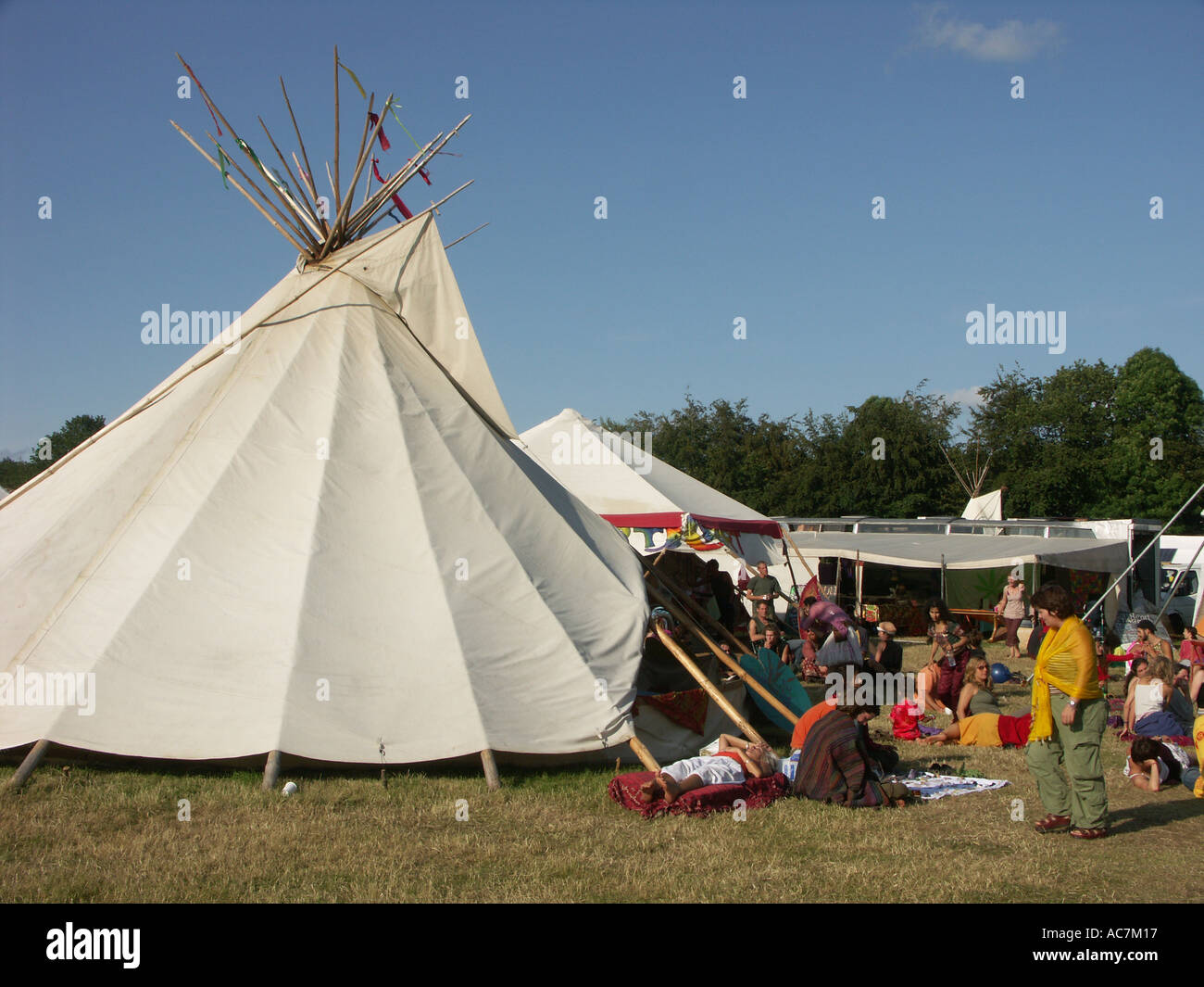 Menschen durch Tipee an einem sonnigen Nachmittag auf dem Dorfplatz beim Buddhafields Festival chillen England uk Stockfoto