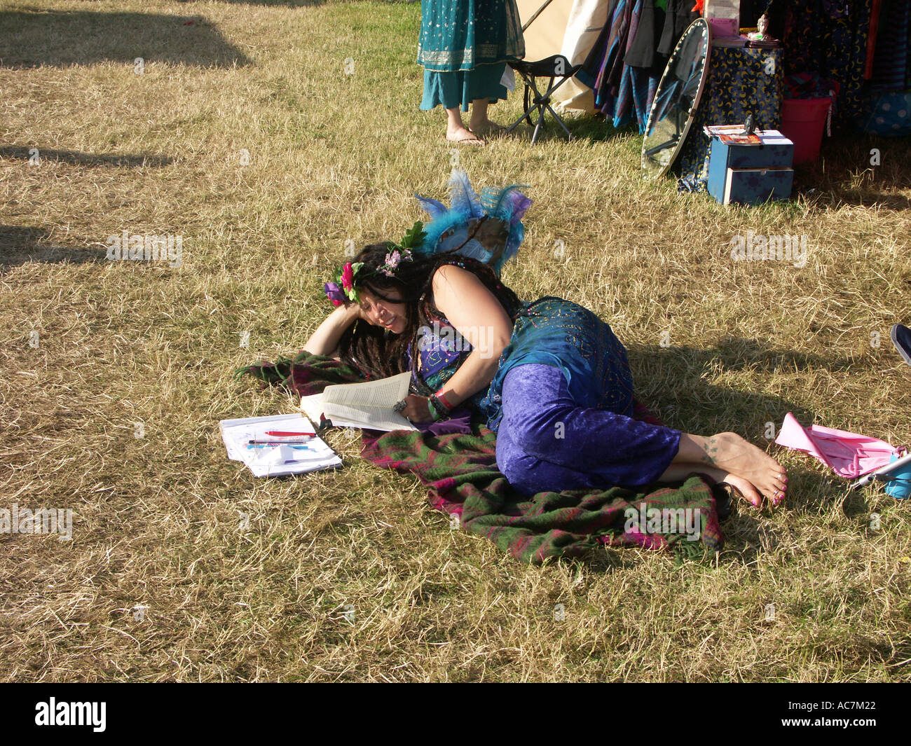 schöne junge Fee Folk lesen auf dem Dorfplatz beim Buddhafields Festival England uk Stockfoto