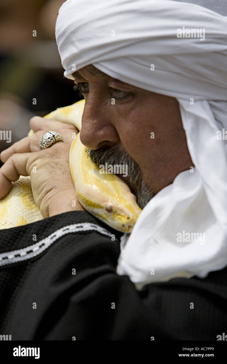 Mann mit weißem Turban küssen große gelbe Python während Mittelaltermarkt, Balmaseda, Baskisches Land, Spanien, Europa. Stockfoto