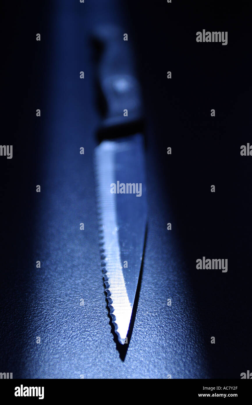 Scharfen Küchenmesser auf schwarzem Hintergrund mit blauer Tönung im Rampenlicht Stockfoto