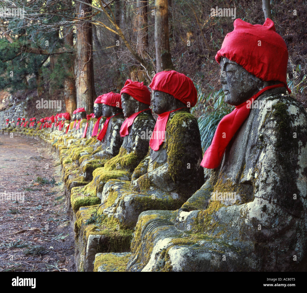 Linie der buddhistischen Jizo (Jizô) Statuen, Bosatsu Vormund der Kinder, die gestorben sind. Roten Lätzchen und Mützen, die oft von Müttern gelegt. Stockfoto