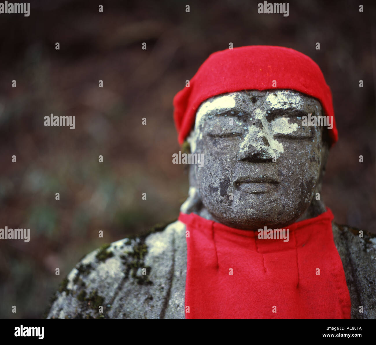 Buddhistische Jizo (Jizô) Statue, Bosatsu Vormund der Kinder, die gestorben sind. Roten Lätzchen und Mützen, die oft von Müttern gelegt. Stockfoto