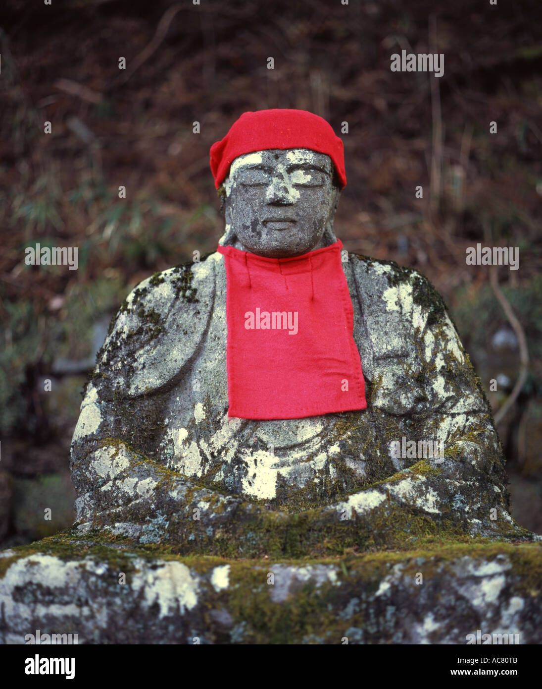 Buddhistische Jizo (Jizô) Statue, Bosatsu Vormund der Kinder, die gestorben sind. Roten Lätzchen und Mützen, die oft von Müttern gelegt. Stockfoto