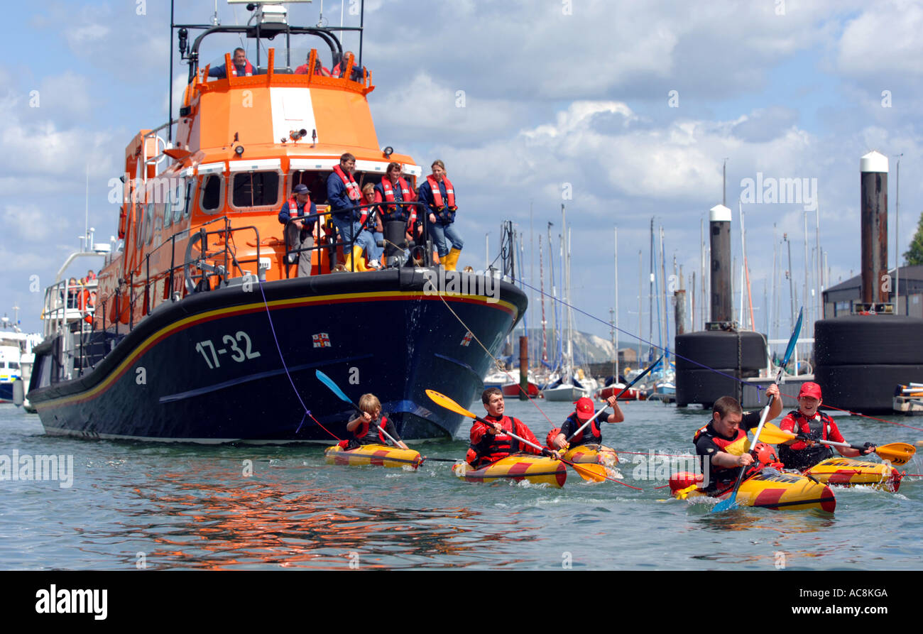 Kanuten ziehen Weymouth Rettungsboot, Weymouth, Dorset England UK Stockfoto