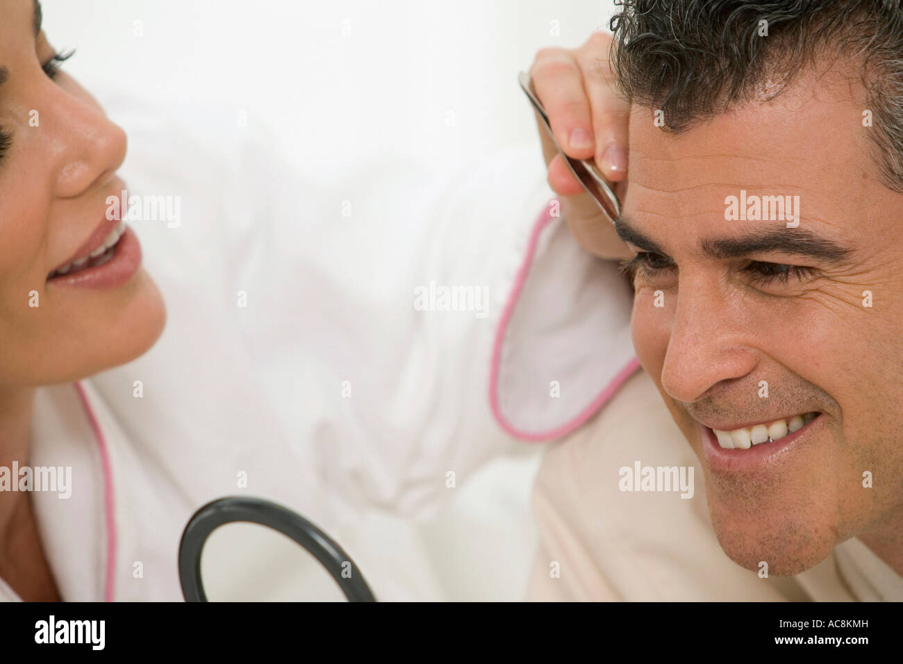 Mitte Erwachsene Frau Zupfen der Augenbrauen ein reifer Mann Stockfoto