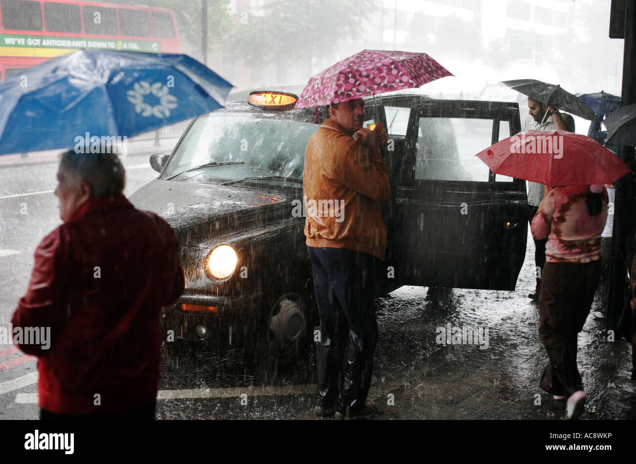 Menschen, gefangen in einem Regen Sturm auf Marylebone Road, London, vorbereiten, Int, ein Taxi zu bekommen. Stockfoto