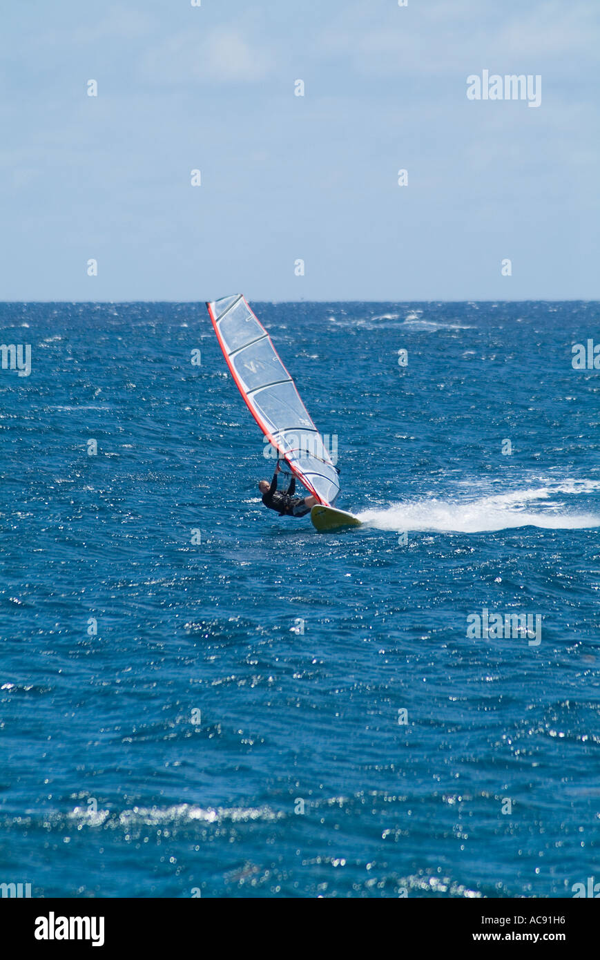 dh Playa de las Cucharas COSTA TEGUISE LANZAROTE Windsurfer fahren Windsurfbrett hart Windsurfen allein Mann segeln Stockfoto