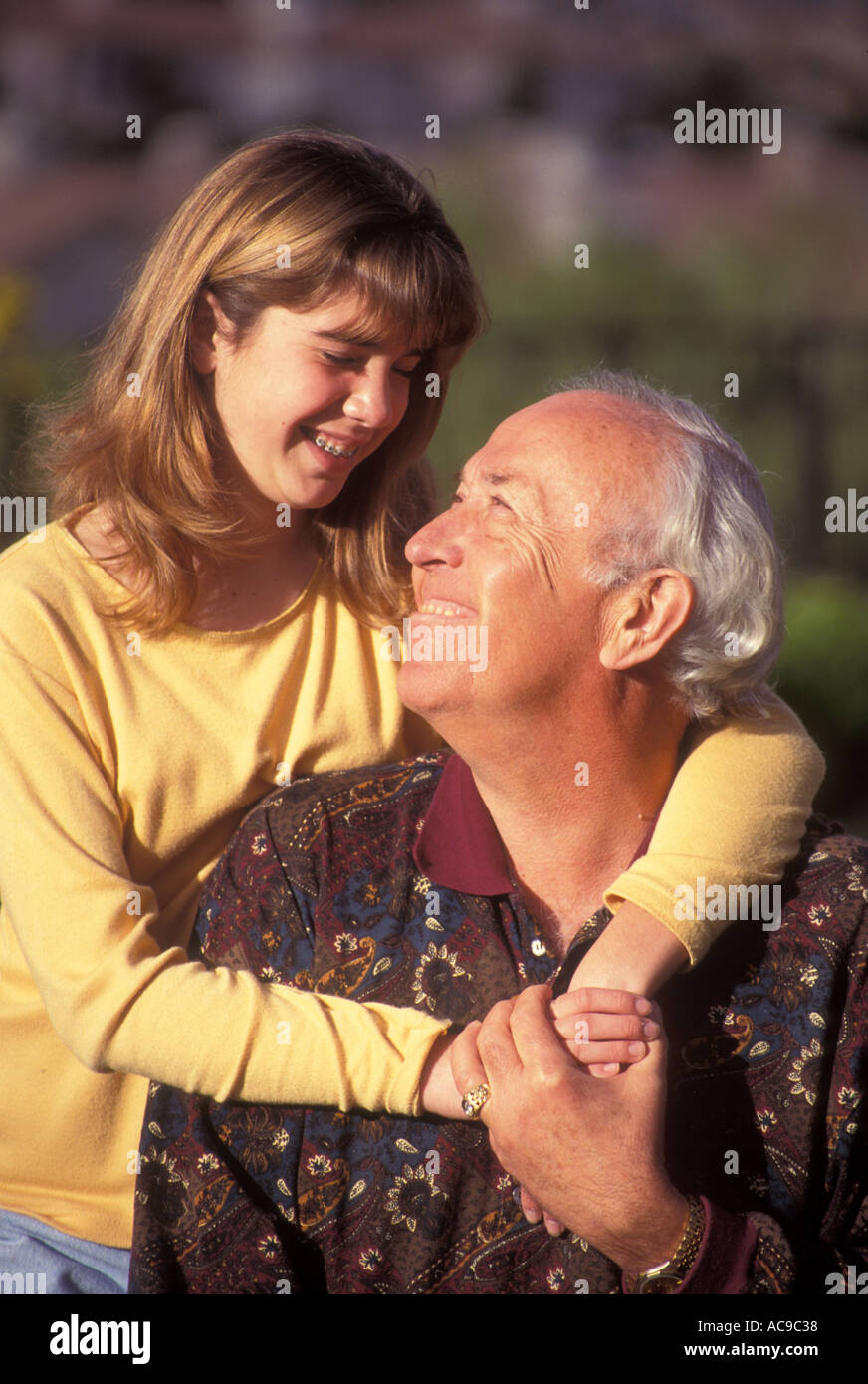 Junge Mensch Menschen Tween tweens Jugendmädchen hinter ihr Großvater umarmen und sich einander im Freien im Hinterhof POV © Myrleen Pearson Stockfoto
