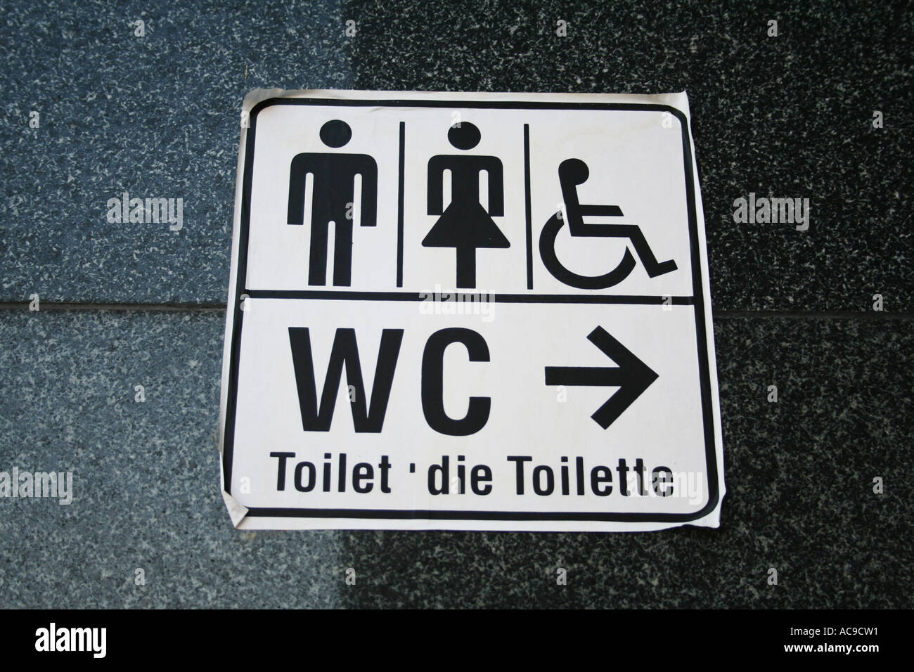 Universelle Schilder für Toiletten, die für Männer, Frauen und barrierefreie Toiletten bestimmt sind, mit mehrsprachigem Text für „Toilette“. Stockfoto