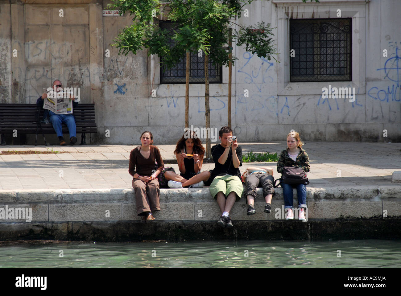 Studenten saßen Kanal in Venedig Italien Stockfoto