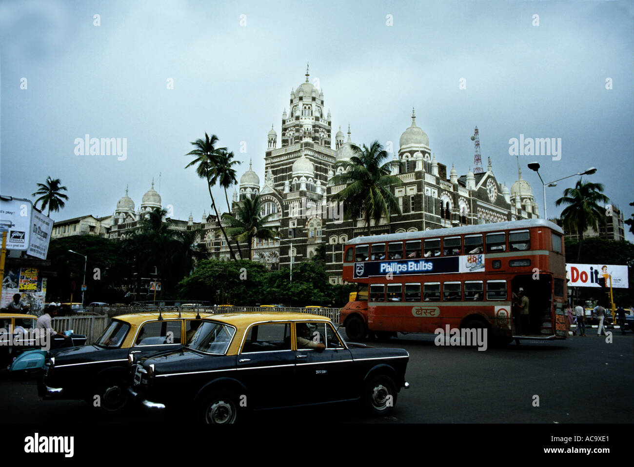 Indien 1985 Bombay Schwerverkehr mit Taxis und ein Double Dutch-Bus unter Gewitterhimmel Stockfoto