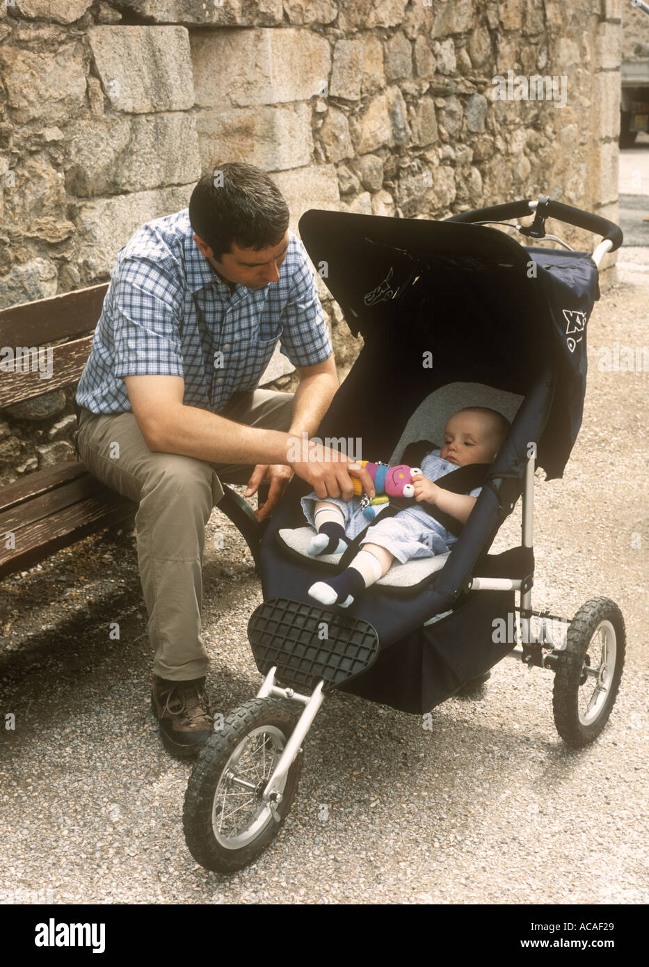 Vater schaut in einem Buggy auf seinen kleinen Sohn, Frankreich Stockfoto