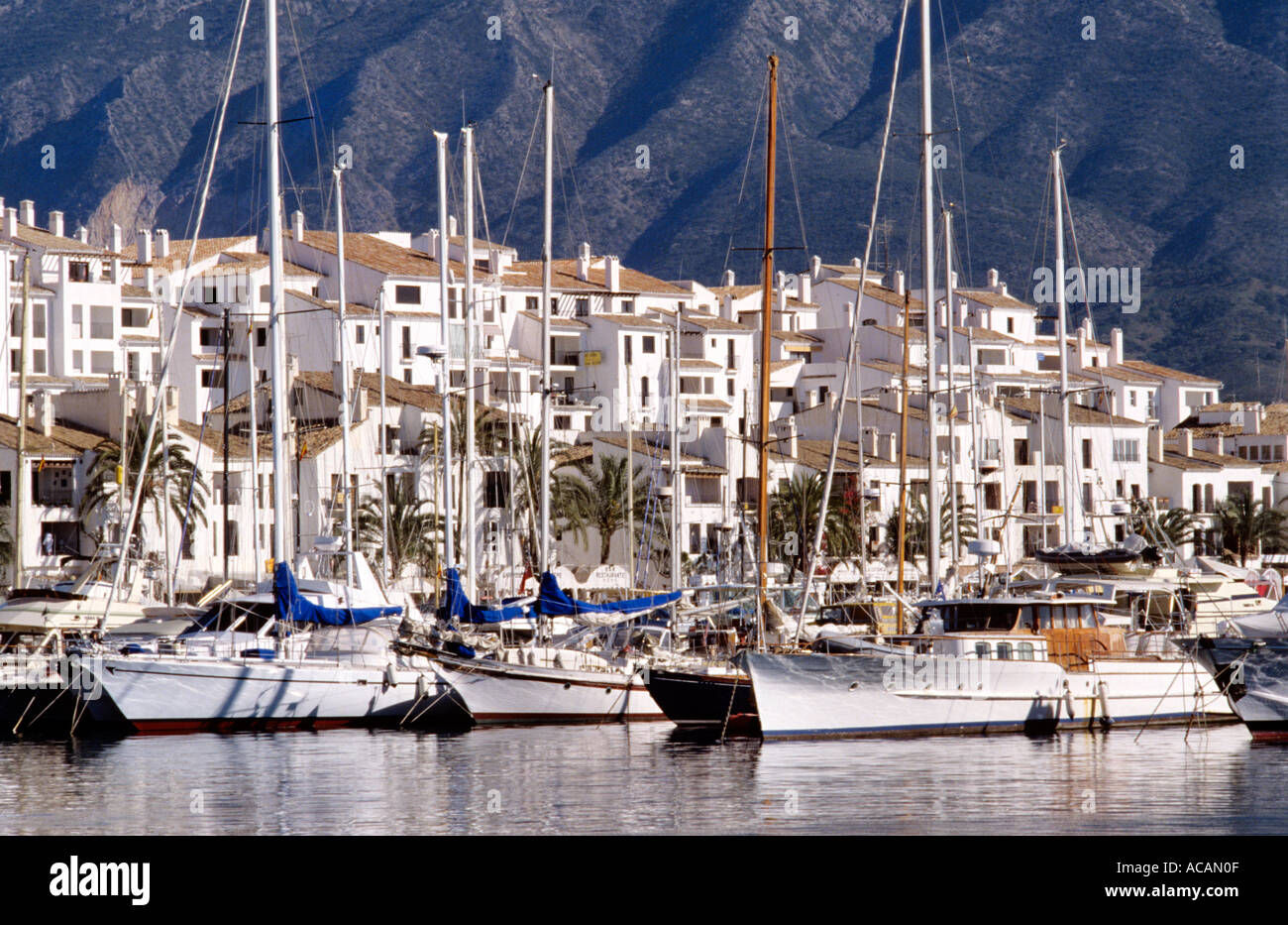 Yachten ankern in Puerto Banus mit luxuriösen Apartments und Villen hinter Costa del Sol Marbella Spanien Stockfoto