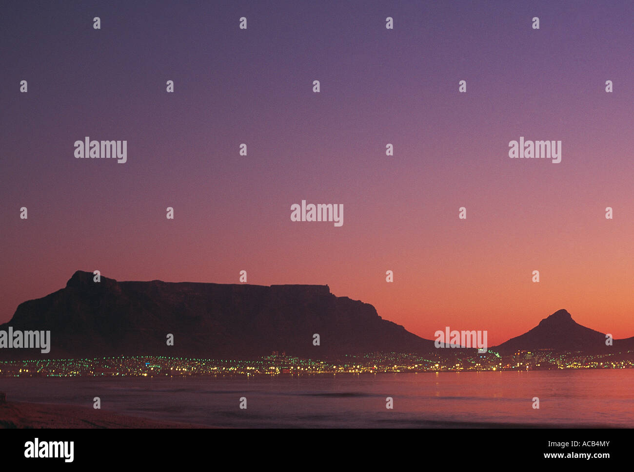 Abends Blick auf Tafelberg und Kapstadt Stadt-Lichter von Milnerton Strand Sonnenuntergang Stockfoto