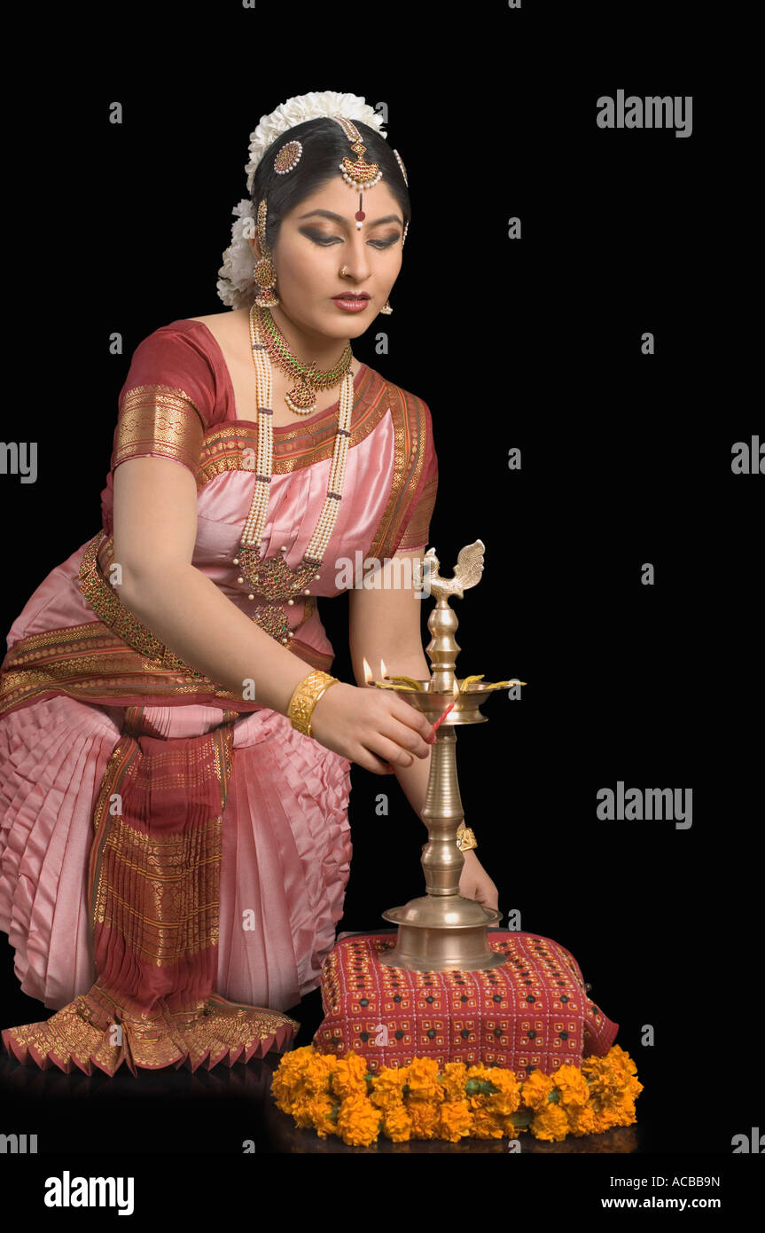 Junge Frau kniend und halten eine zeremonielle Lampe Stockfoto