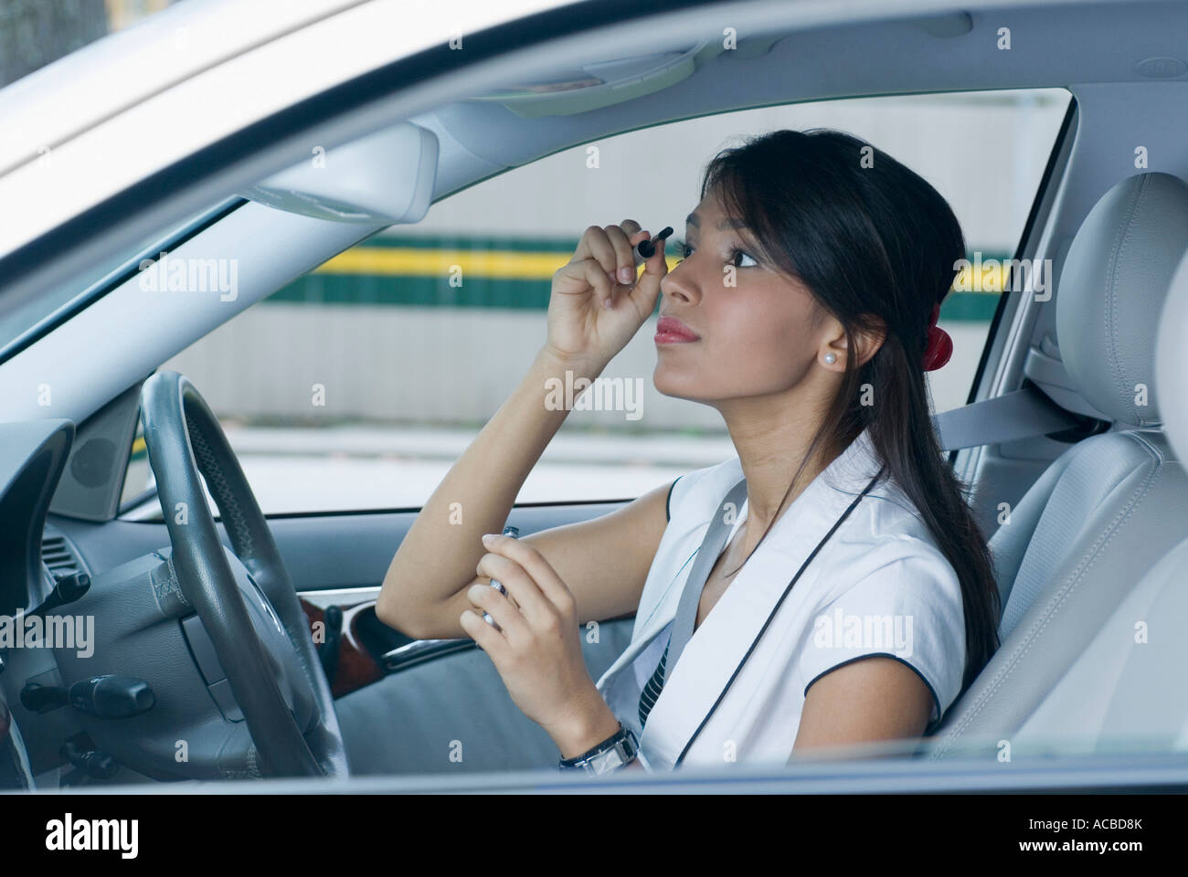 Seitenansicht einer Mitte erwachsenen Frau mit einem Wimpern und Augenbrauen Kamm im Auto Stockfoto