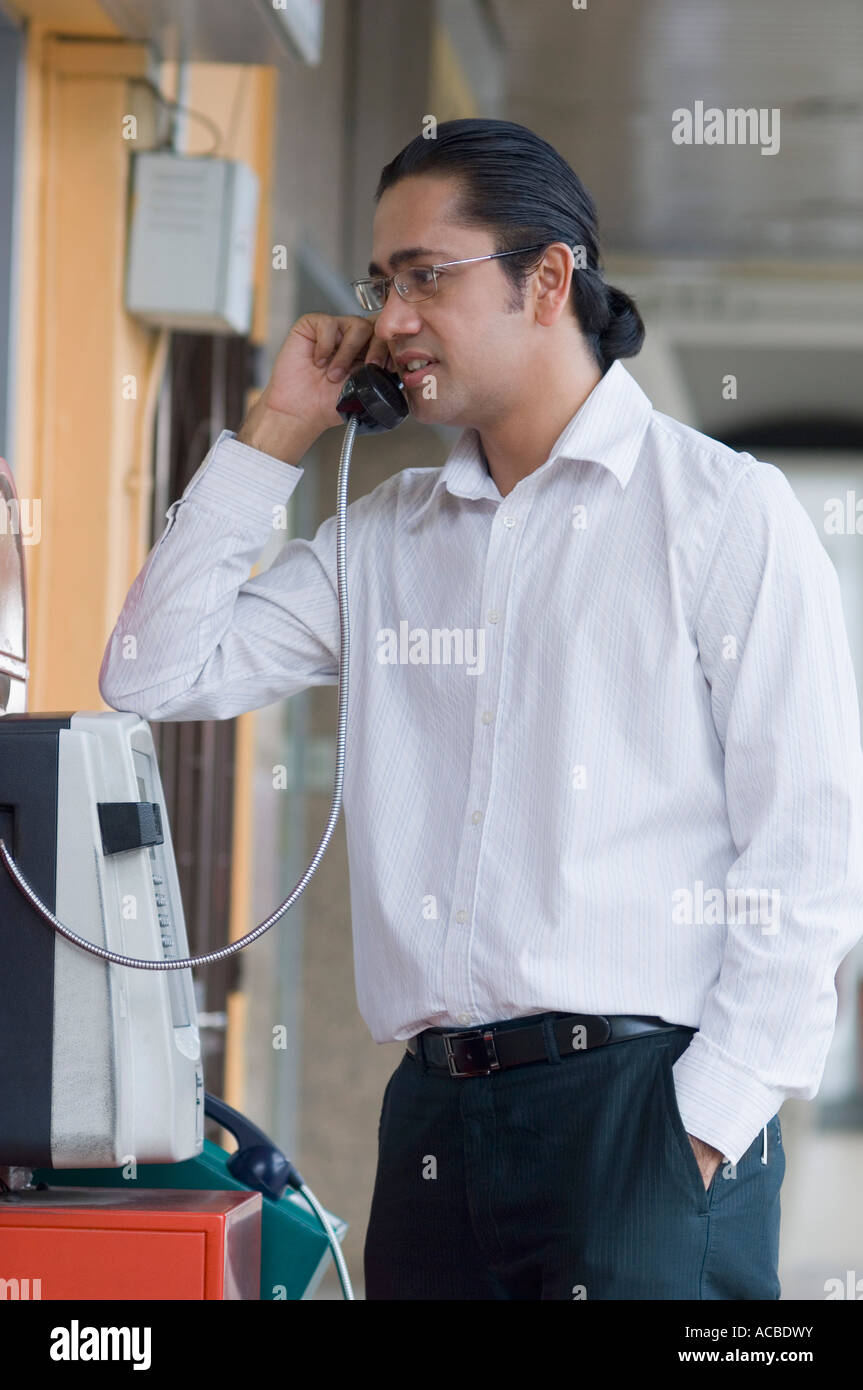 Mitte erwachsenen Mannes reden auf einer Telefonzelle Stockfoto