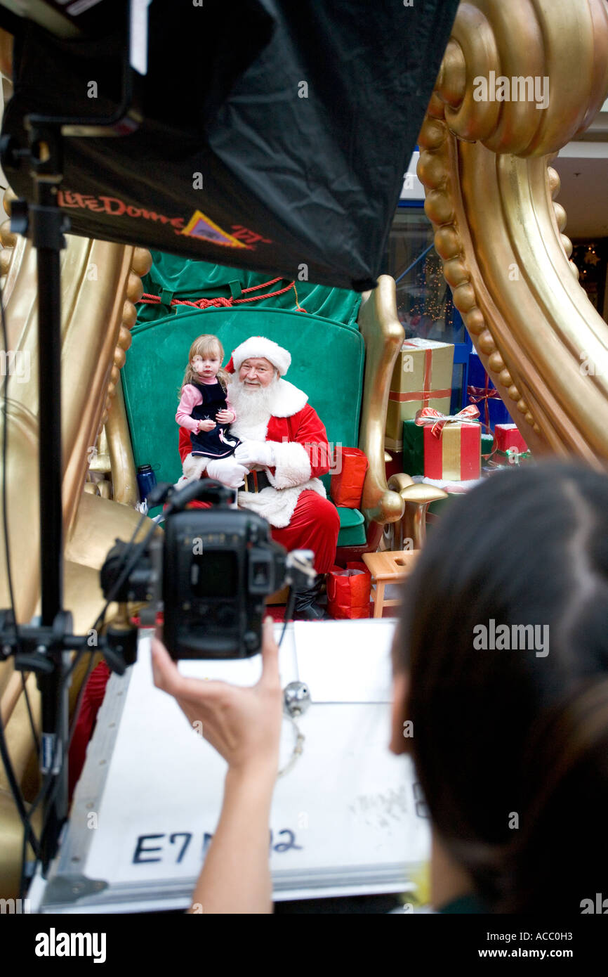 Foto von einer Mall Santa posieren für Bilder mit einem kleinen Kind Stockfoto