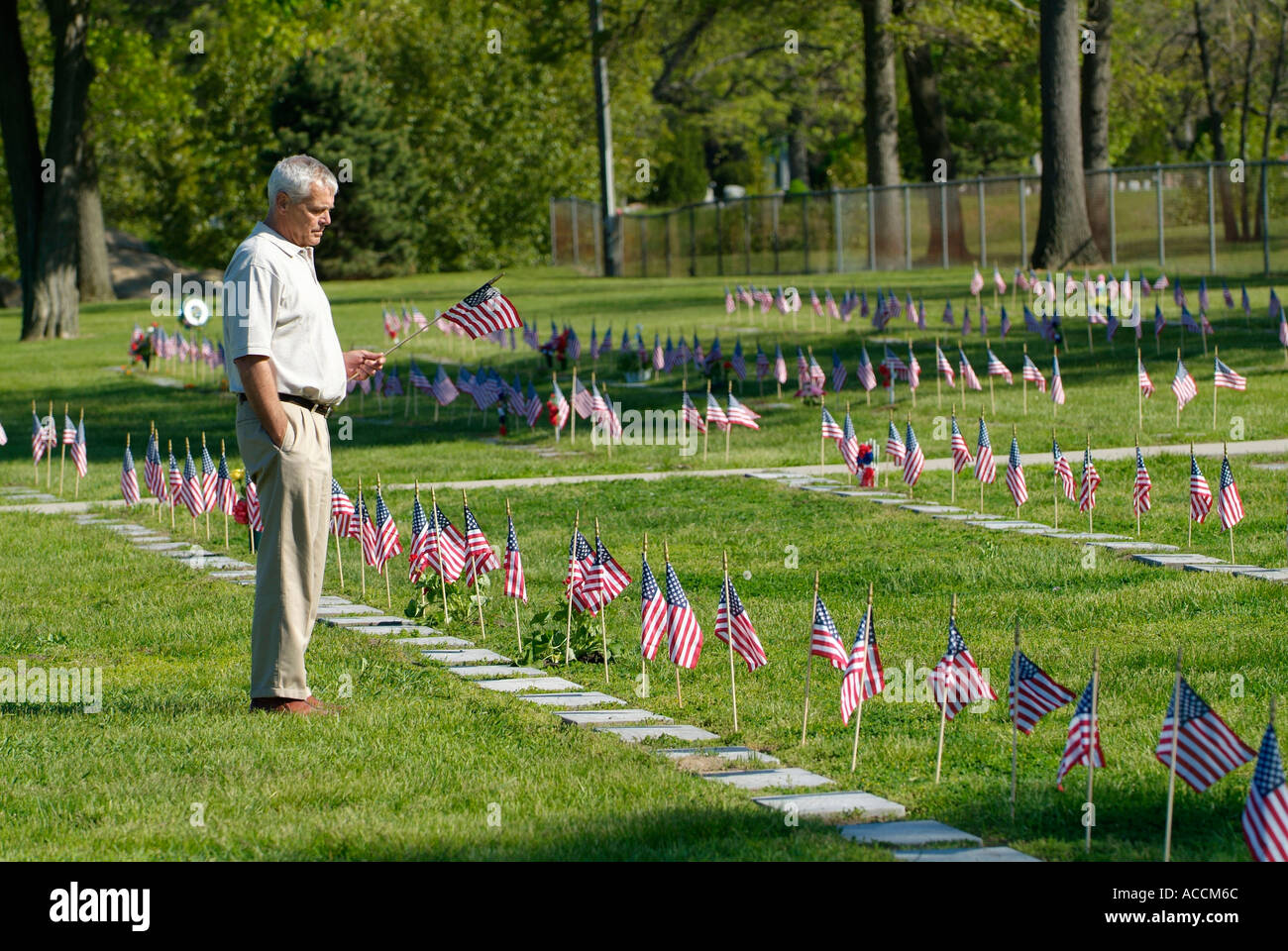 Familie besucht Friedhof am Memorial Day, Flaggen auf Gräbern zu platzieren Stockfoto