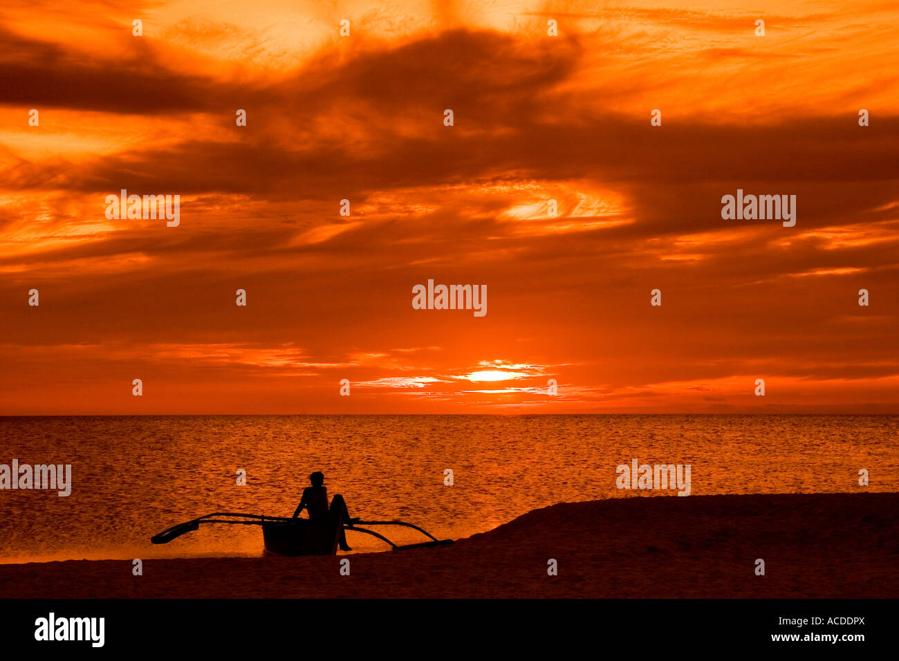 Ein Fischer wartet, bis Sonnenuntergang, bevor er an die Meeresfische in Camiguin, Philippinen geht Stockfoto