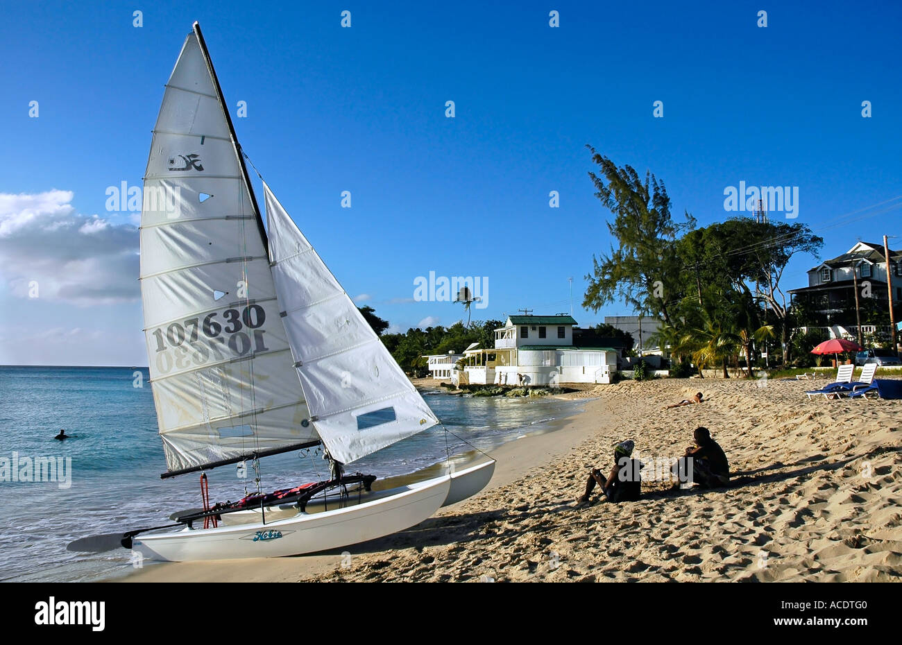 Segelboot und Silhouetten am Strand von Barbados, Caribbean Stockfoto