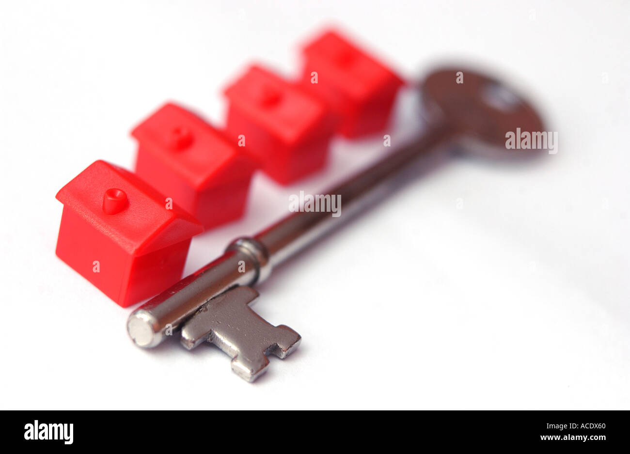 Monopoly-Häuser und ein Schlüssel in der Form des Zeichens Sterling Großbritanniens Währung Hypotheken Stockfoto