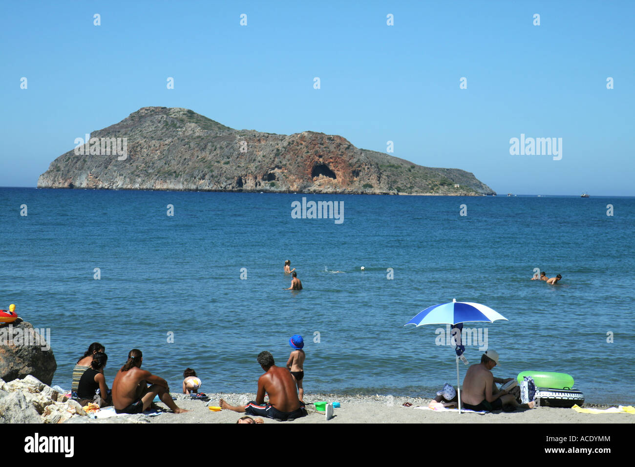 Touristen am Strand von Platanias, Kreta, Griechenland. Im Hintergrund sehen Sie die Insel Thodorou Stockfoto