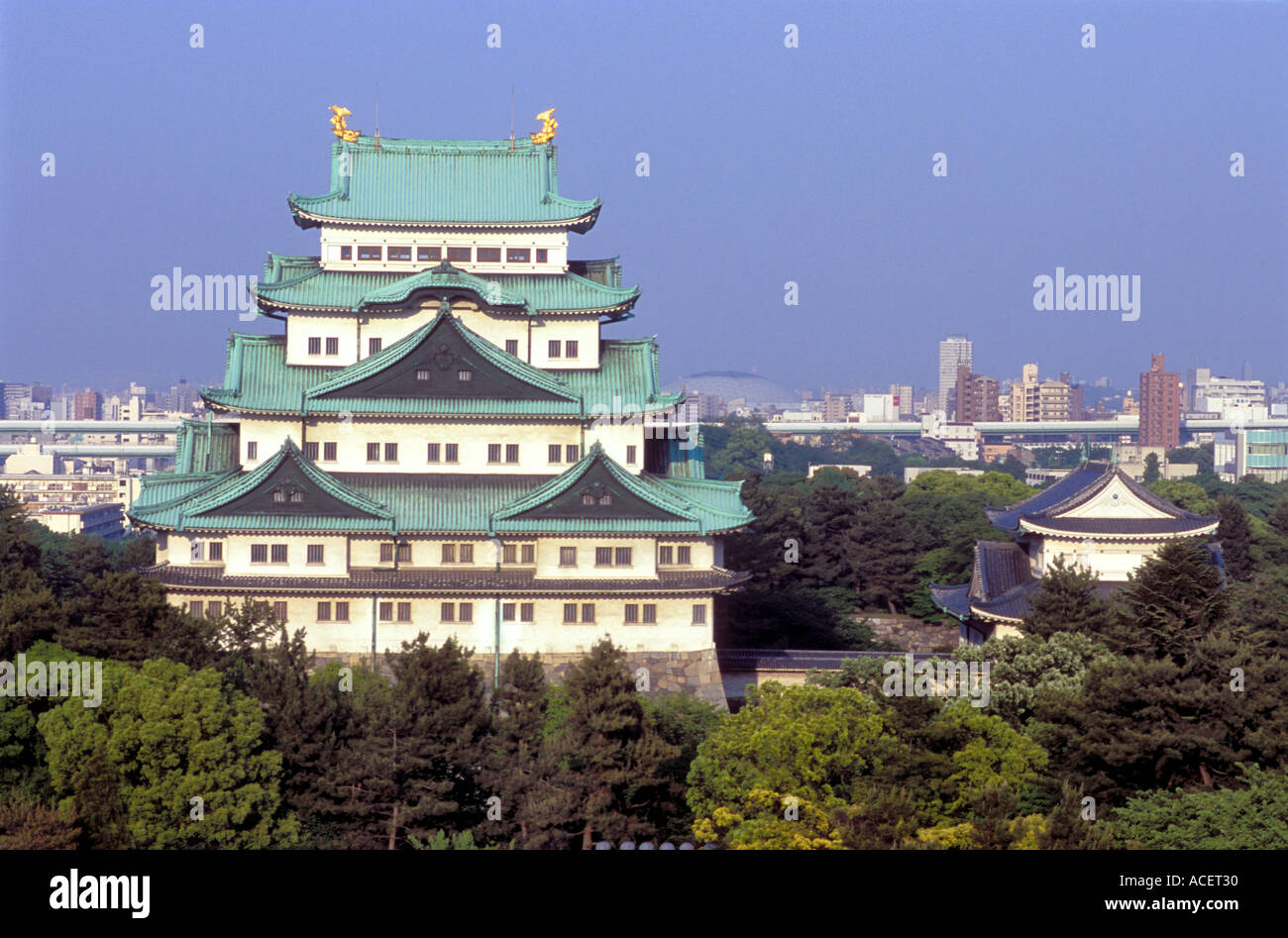 Nagoya Castle, umgeben von Bäumen mit Blick auf die Stadt Skyline hinter Stockfoto