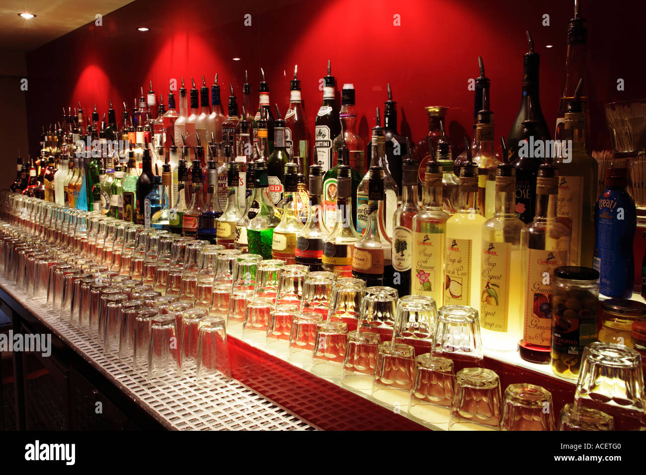 Reihe von alkoholischen Getränkeflaschen auf eine Pub-Bar mit Brille, UK Stockfoto