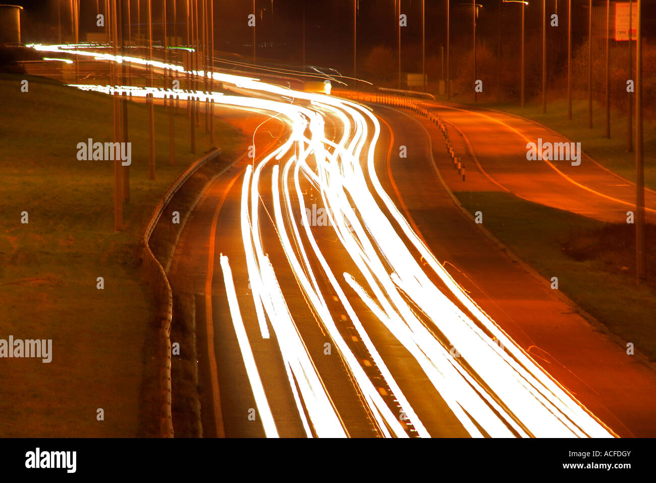 Beschleunigung Lichtspuren von Verkehr auf einer belebten Straße in der Nacht, allgemeine Straßen, Autobahn Stockfoto