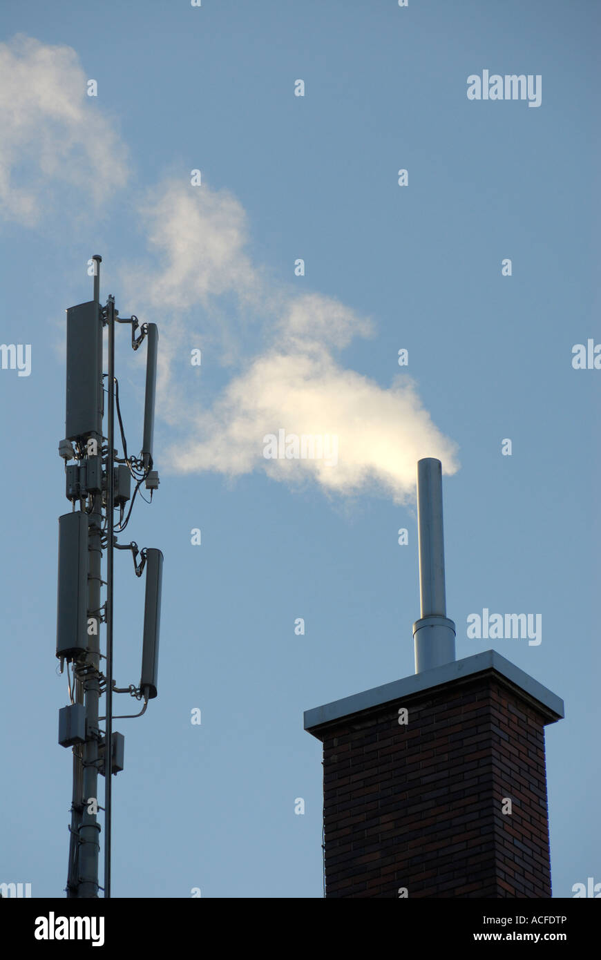 Antenne für Mobilfunk-Übertragung und Rauchen Schornstein auf einem Hausdach in Zürich, Schweiz. Stockfoto