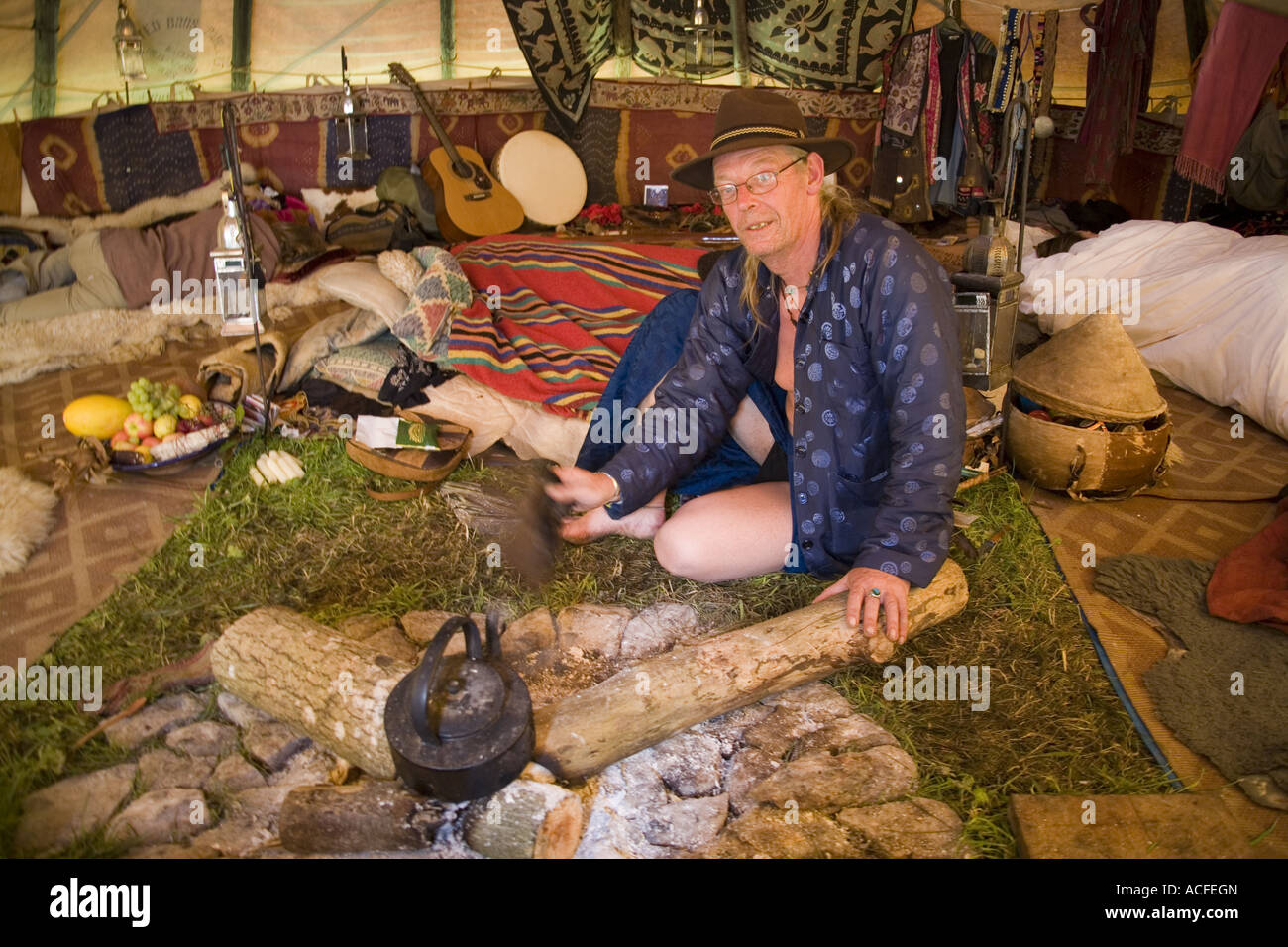 "Medizin-Brother" Phil neigt dazu, das Feuer im Inneren einer Familiengröße Tipi. Glastonbury Festival 2007, Somerset, England Stockfoto