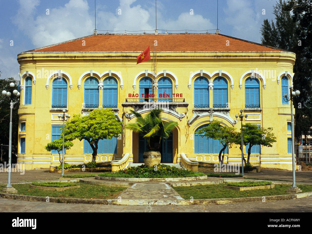 Gelb bemalte Fassade des französischen Kolonialstil Bao Tang Revolution Museumsbau, Ben Tre, SW Viet Nam Stockfoto