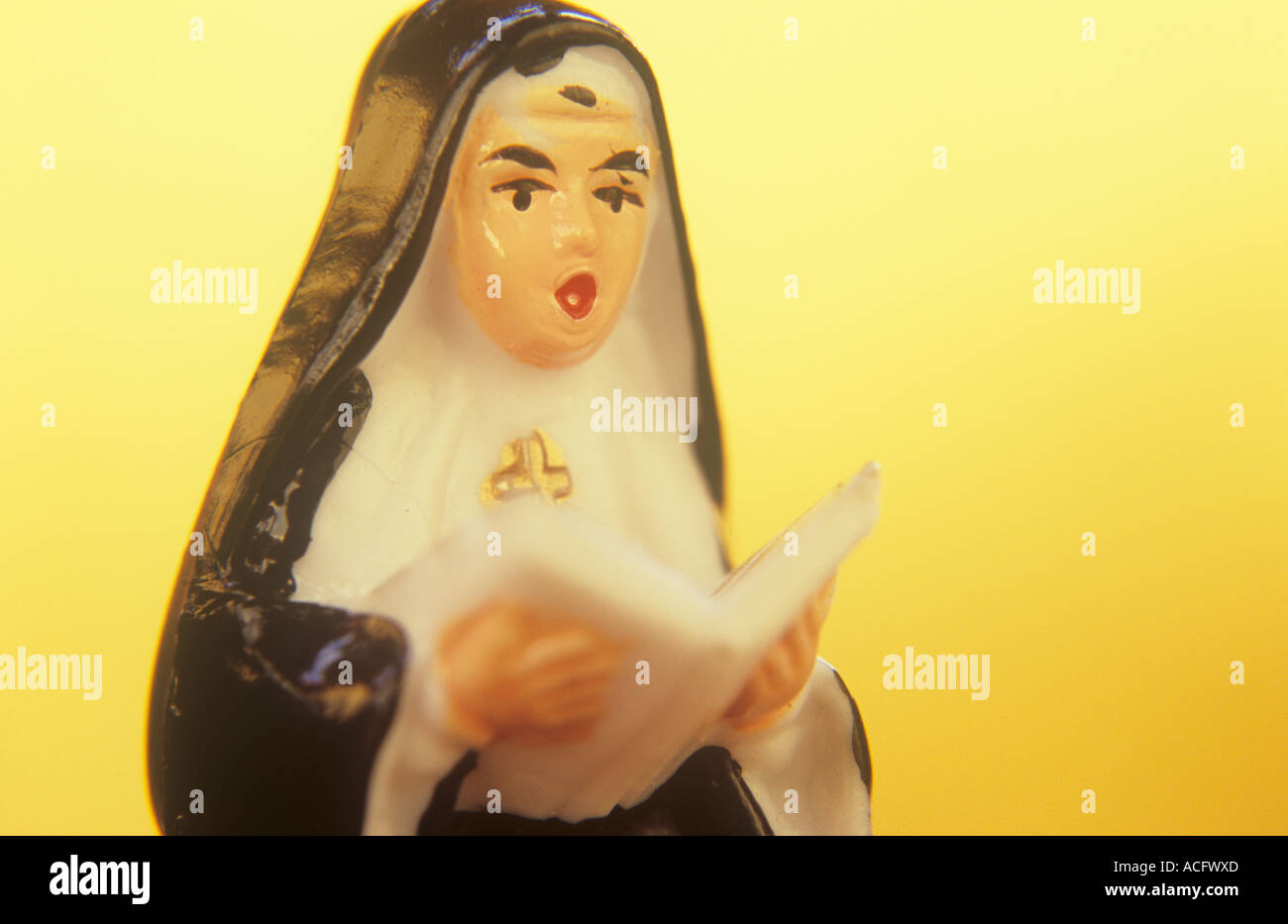 Nahaufnahme in warmen goldenen Licht der Kunststoff Miniaturmodell einer Nonne aus einem Buch von Hymnen und Psalmen singen Stockfoto