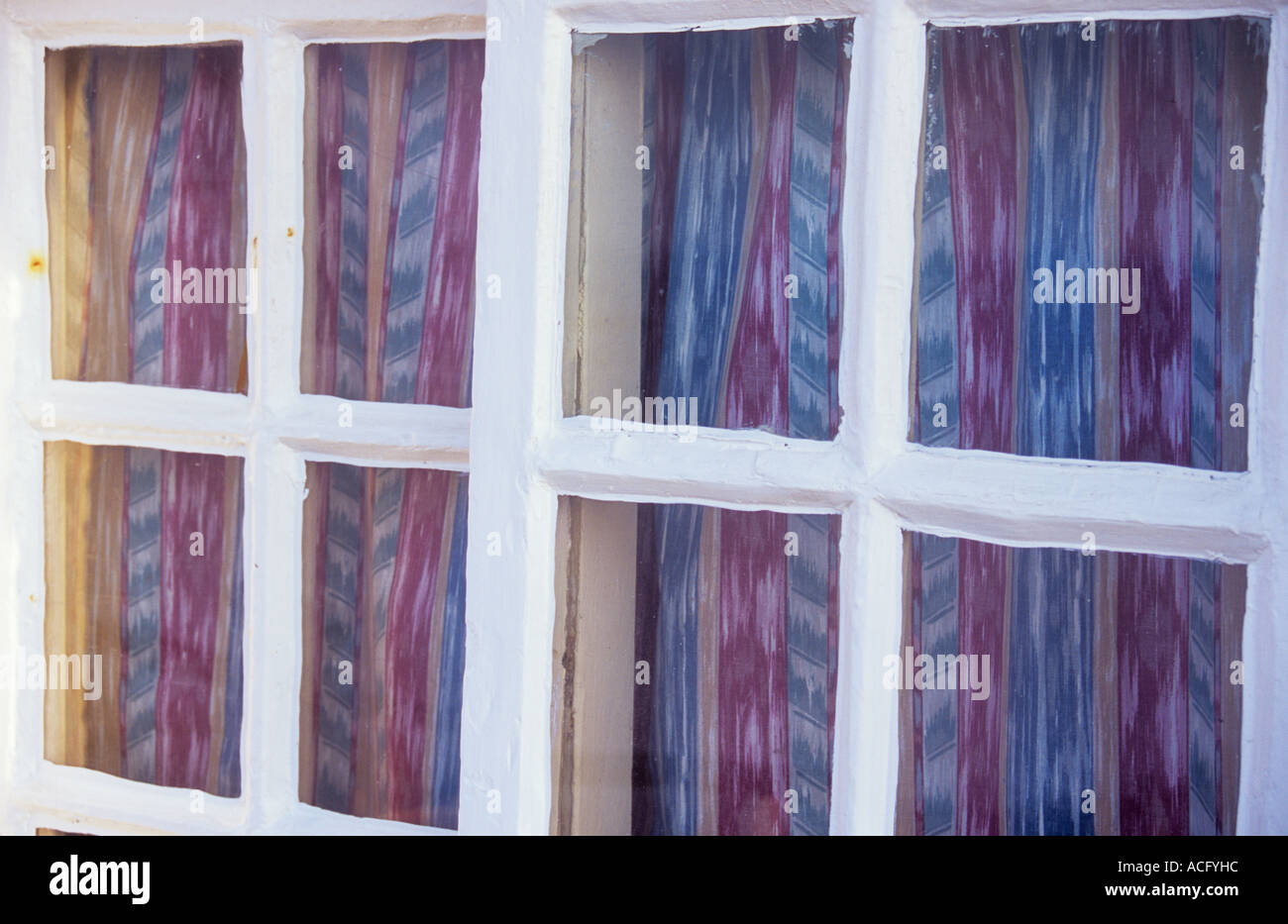 Nahaufnahme Detail eine Strandhütte, Gartenhaus oder Ferienhaus mit weiß lackierten Fensterrahmen und rot und blau gestreiften Vorhänge Stockfoto