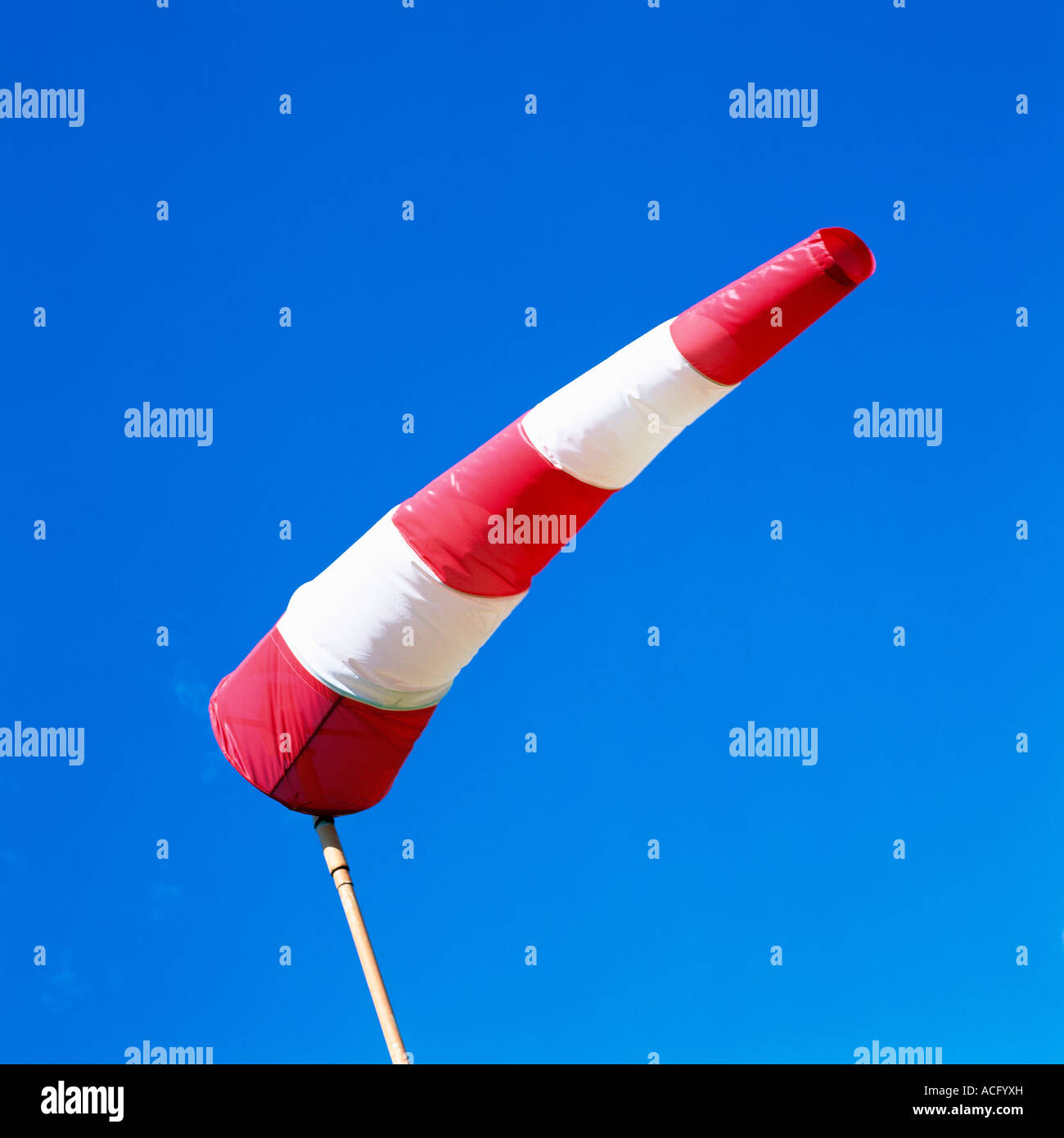 Eine rote und weiße Wetterfahne gegen und ein strahlend blauer Himmel. Stockfoto