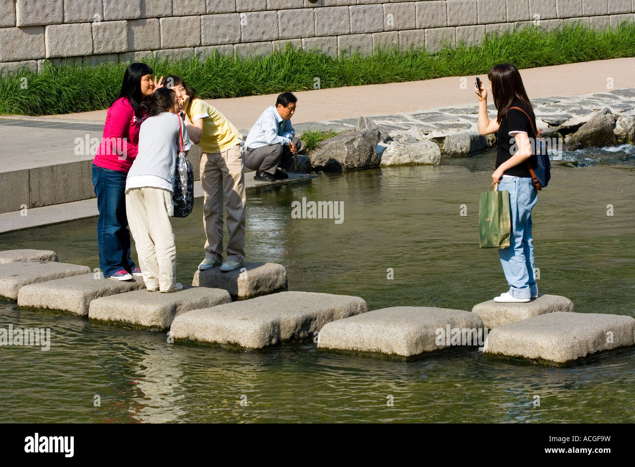 Koreanische Mädchen, die die Handy Bild Cheonggyecheon oder Cheonggye Stream Seoul Südkorea Stockfoto