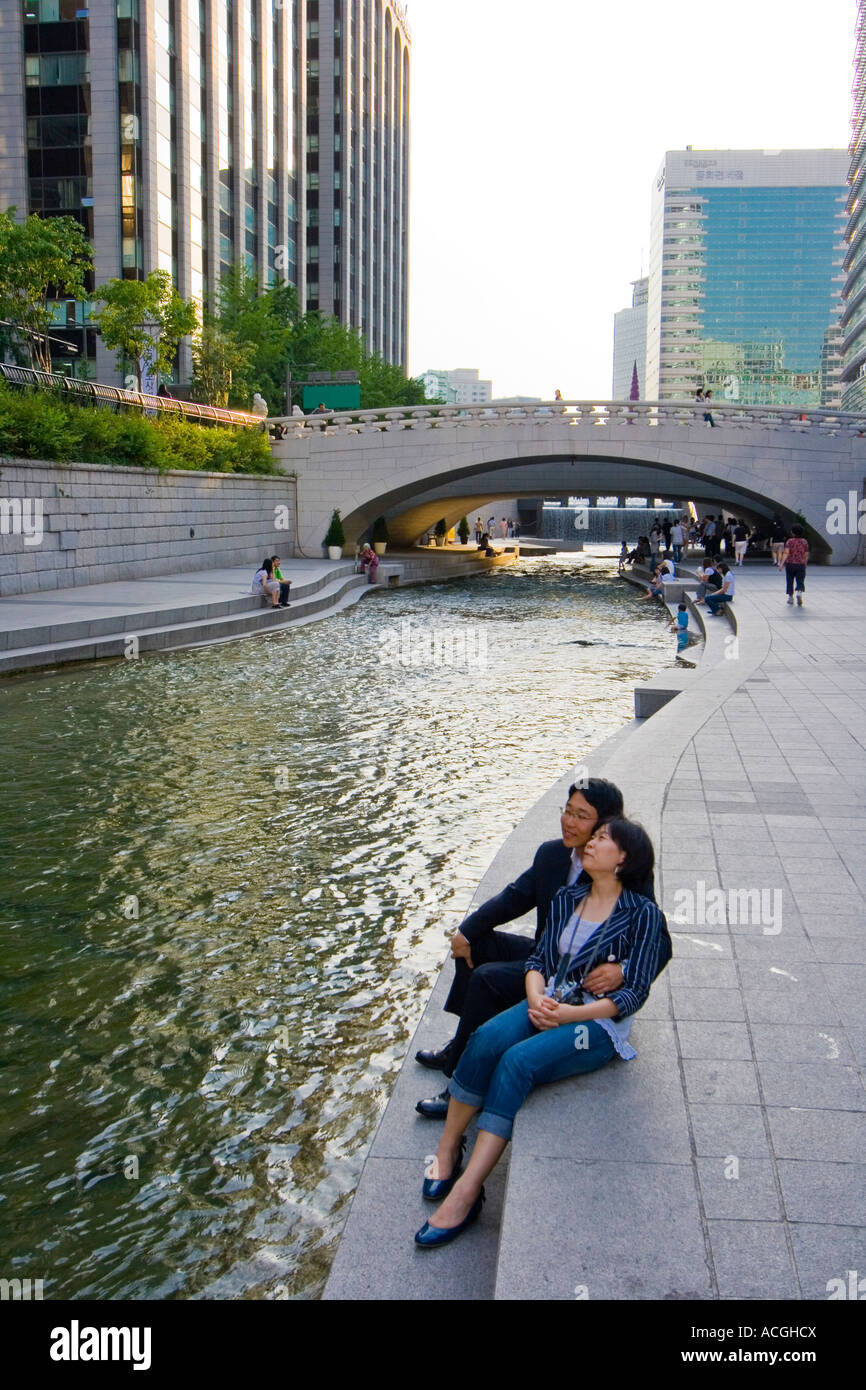 Mittleren Alters paar sitzen zusammen neben Cheonggyecheon oder Cheonggye Stream Seoul Südkorea Stockfoto