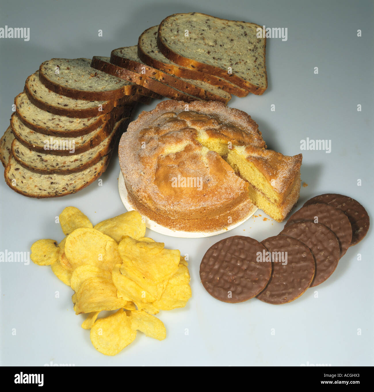 Beispiele für hochenergetische kohlenhydratreiche Lebensmittel Kuchen Chips Kekse Schokolade Brot Stockfoto