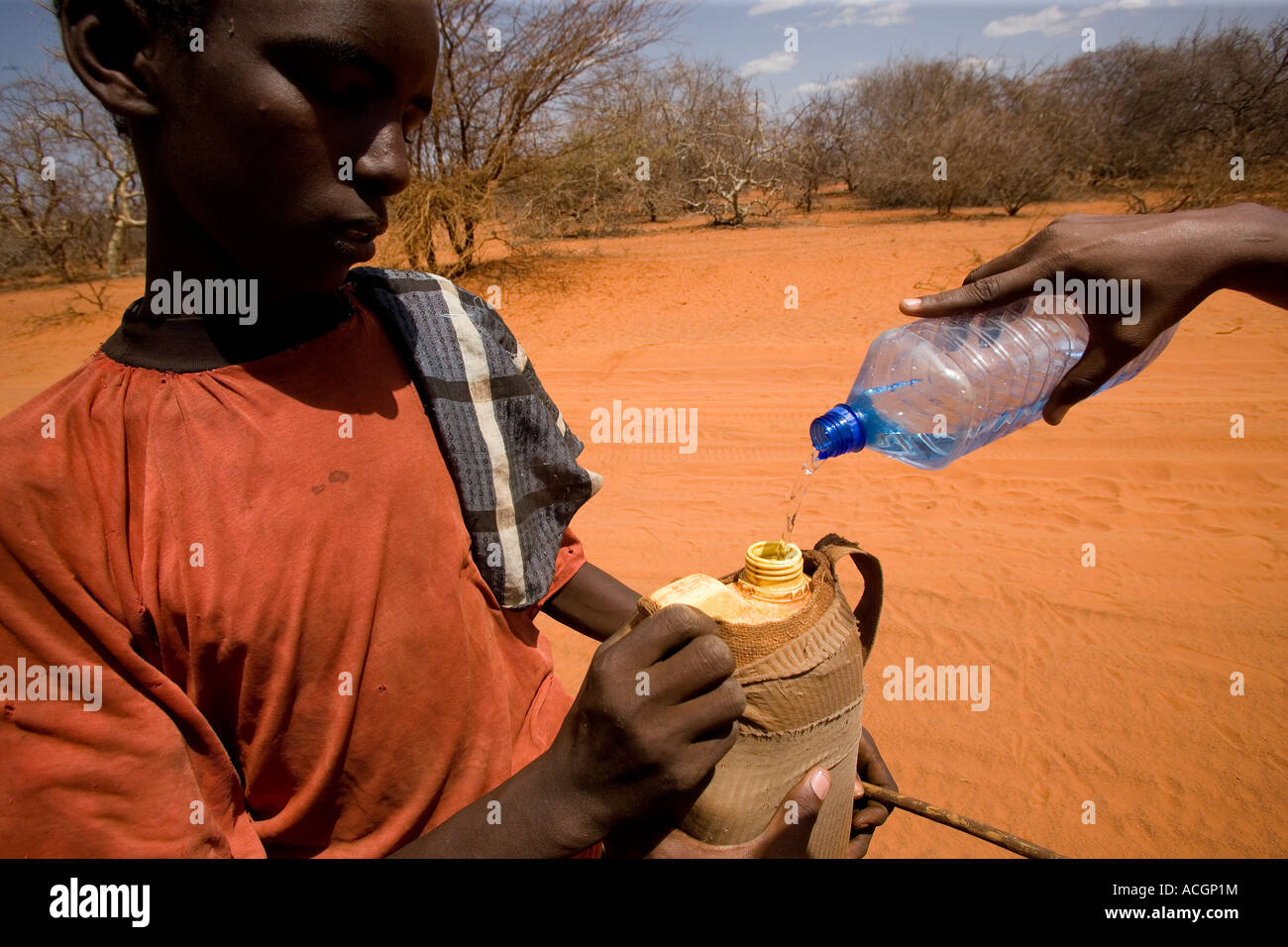 Nord-Ost-Kenia 6. März 2006 Nomad junge bekommt Wasser von einem vorbeifahrenden Autofahrer während der schlimmsten Dürre in 20 Jahren Stockfoto
