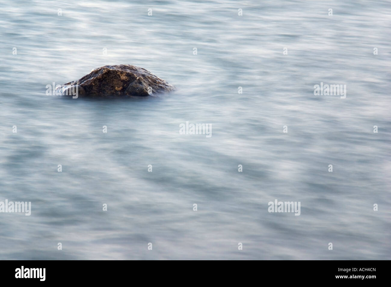 Landschaft / horizontale Foto verwackelt Wasser um einen einzigen Granitfelsen, die fast einen Kopf Krokodile ähnelt Stockfoto
