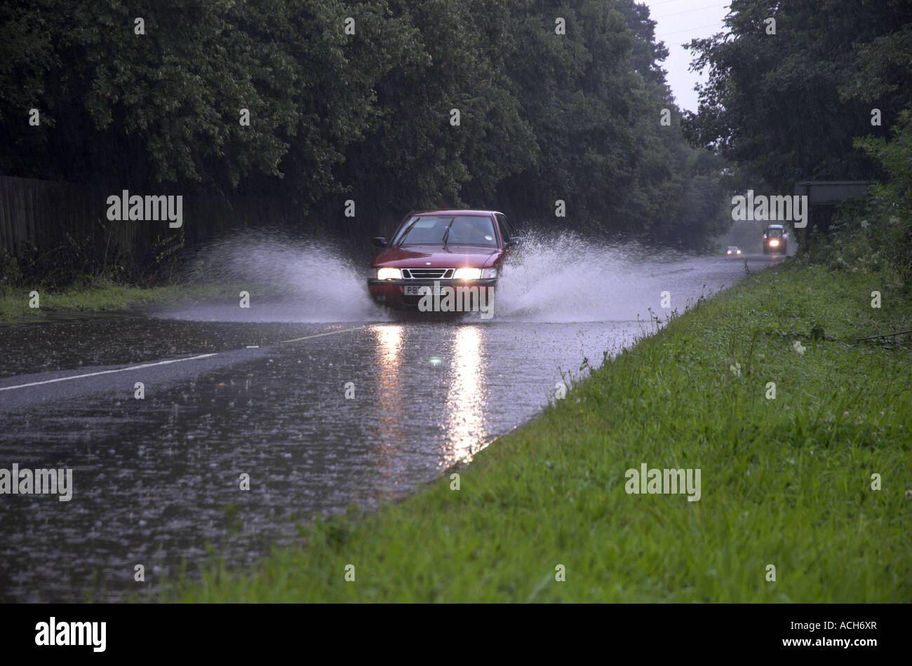 Auto fahren durch überfluteten Straße Besprühen mit Wasser nach starken Regenfällen Stockfoto