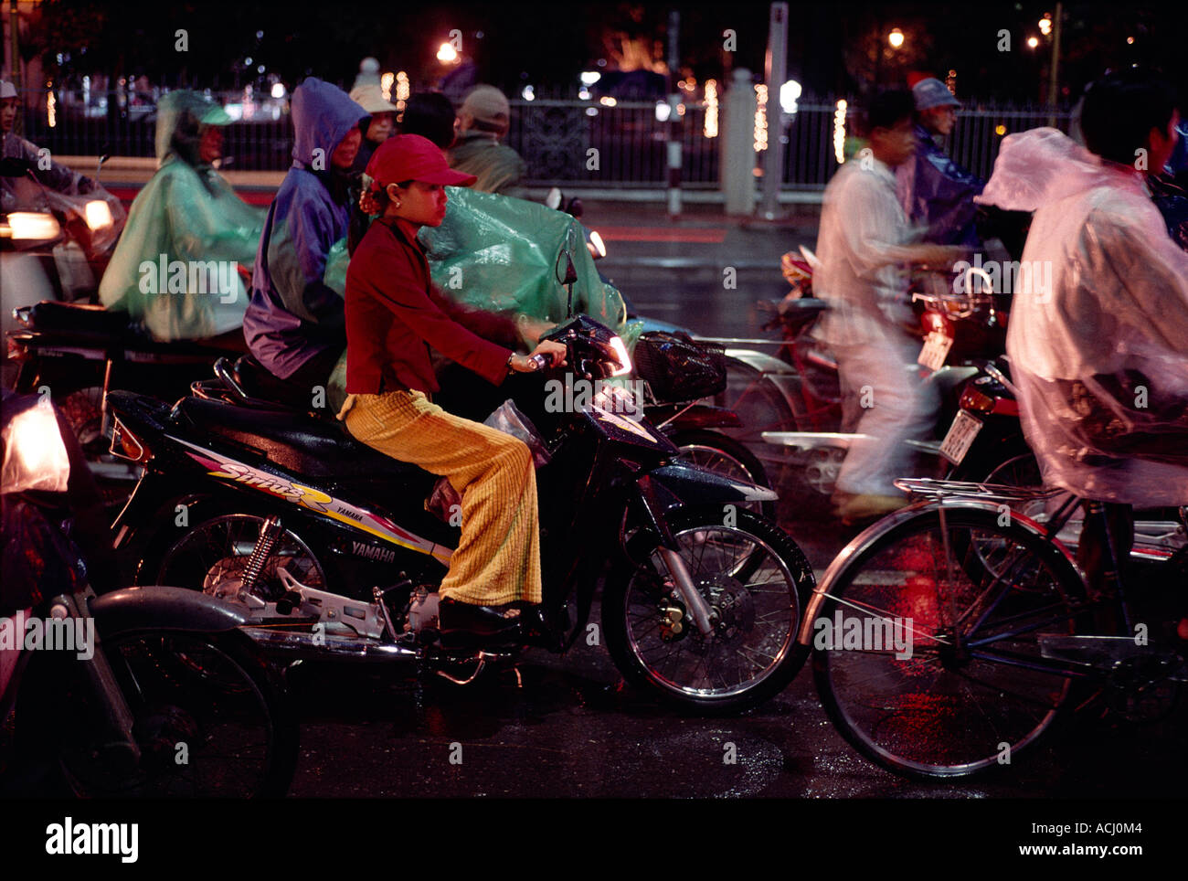 Asien-Vietnam-Hu-junge Frau sitzt auf dem Motorrad an der Ampel in Regen auf Phu Xuan Brücke über Mekong River Stockfoto