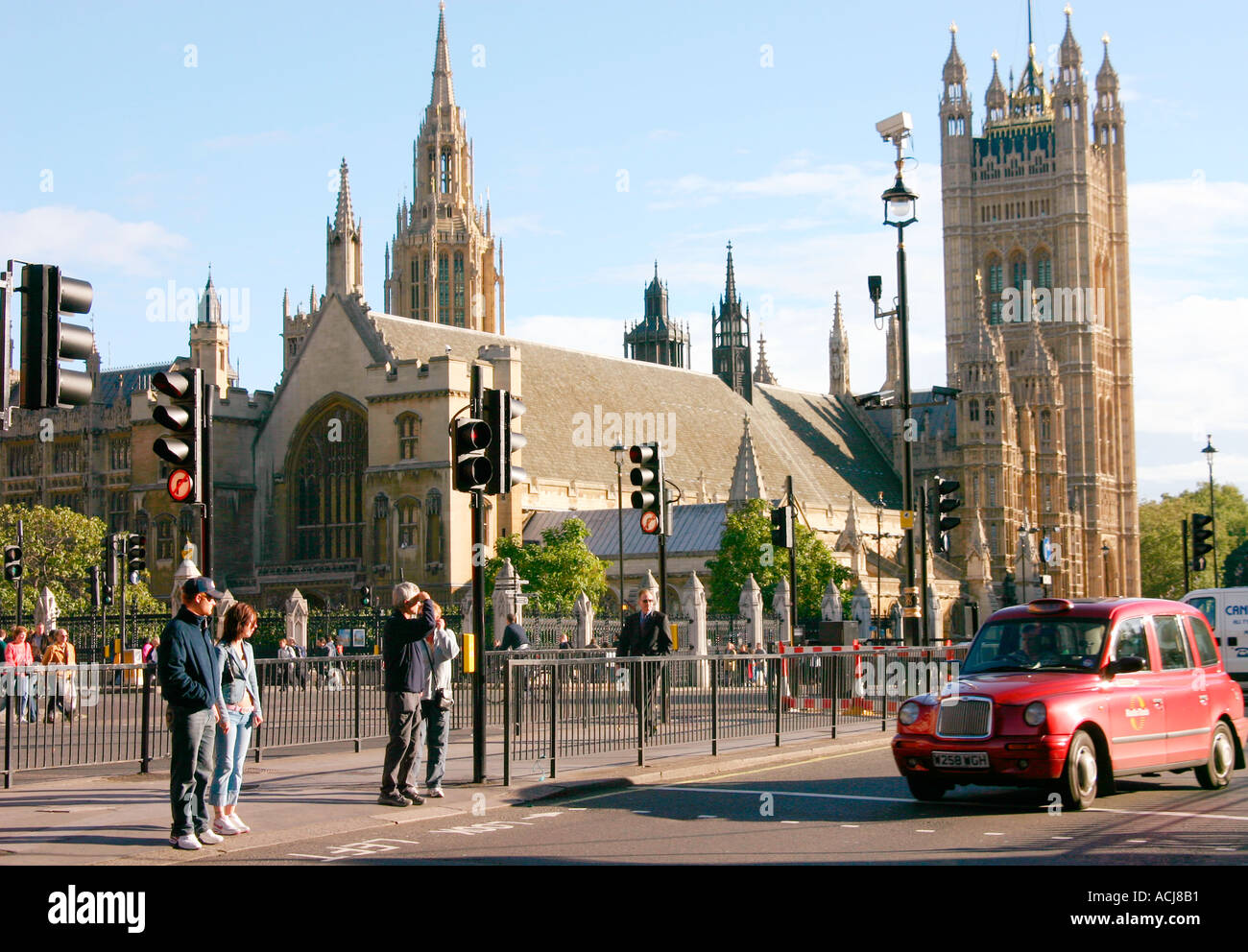 Menschen Kreuzung Straße an der Ampel mit roten Taxis und Westminster Abbey in London Stockfoto
