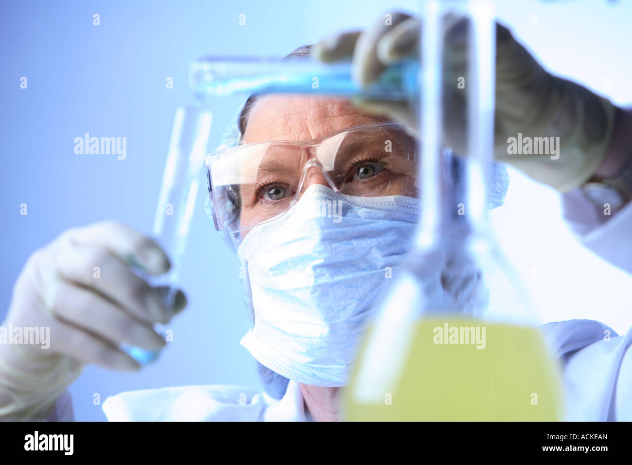 Frau im Labor gießt Flüssigkeit in Reagenzglas Stockfoto