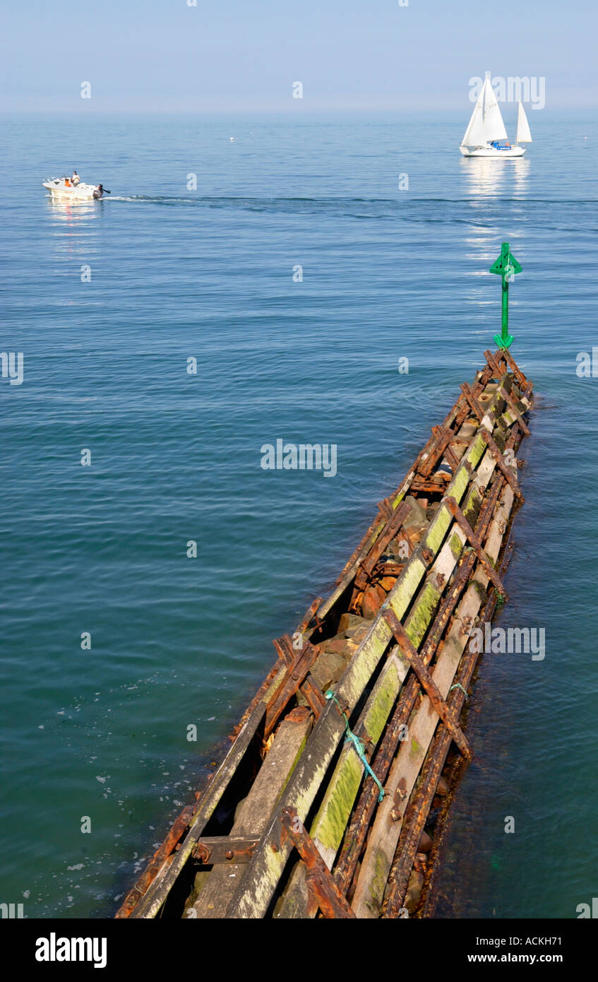 Wellenbrecher und Yacht am blauen Meer an Aberaeron Strand Ceredigion West Wales UK GB Stockfoto