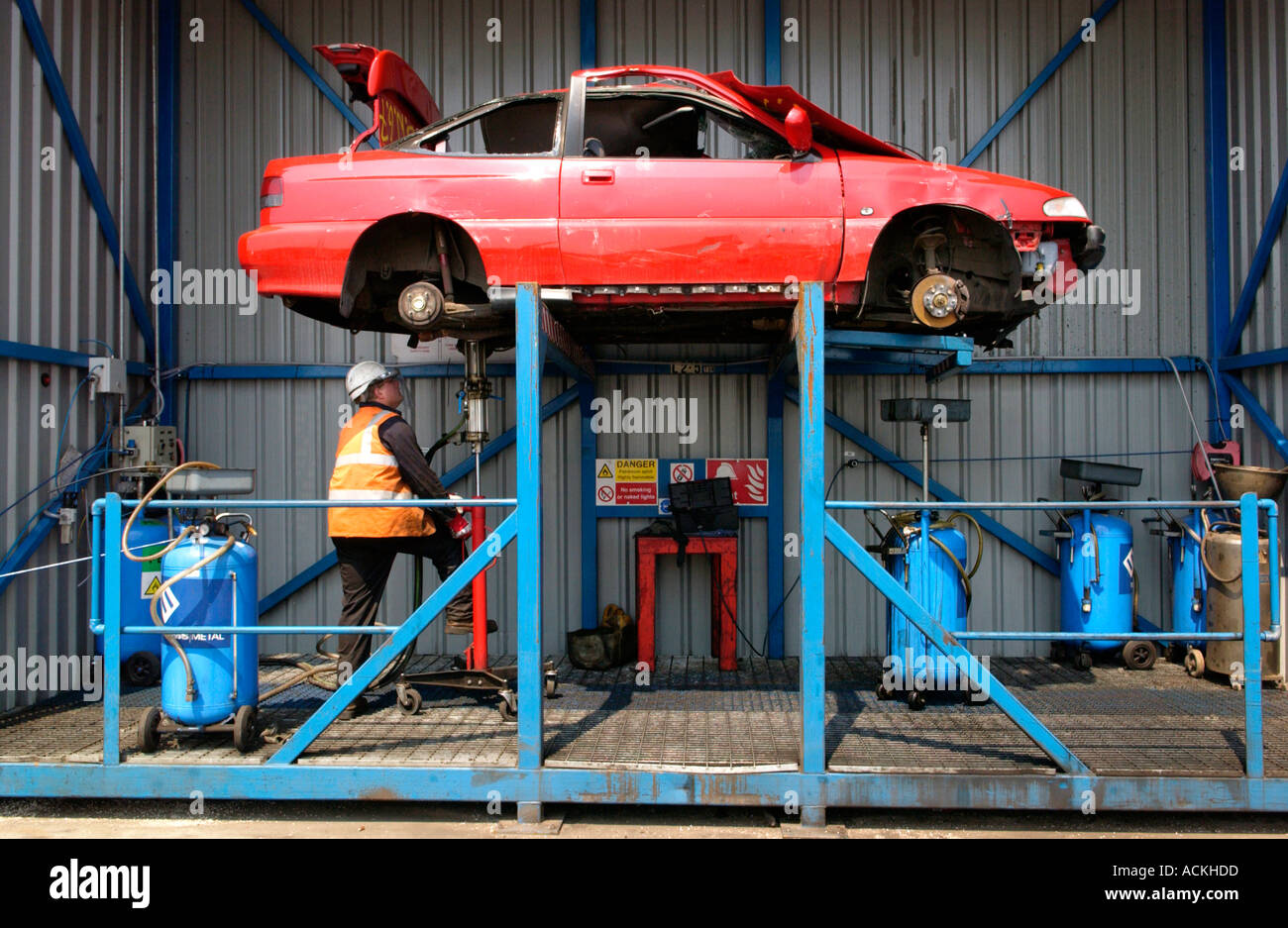 Entfernen von Flüssigkeiten aus einem Auto vor dem recycling bei einer autorisierten Verwertungsanlage in Newport South Wales UK Stockfoto