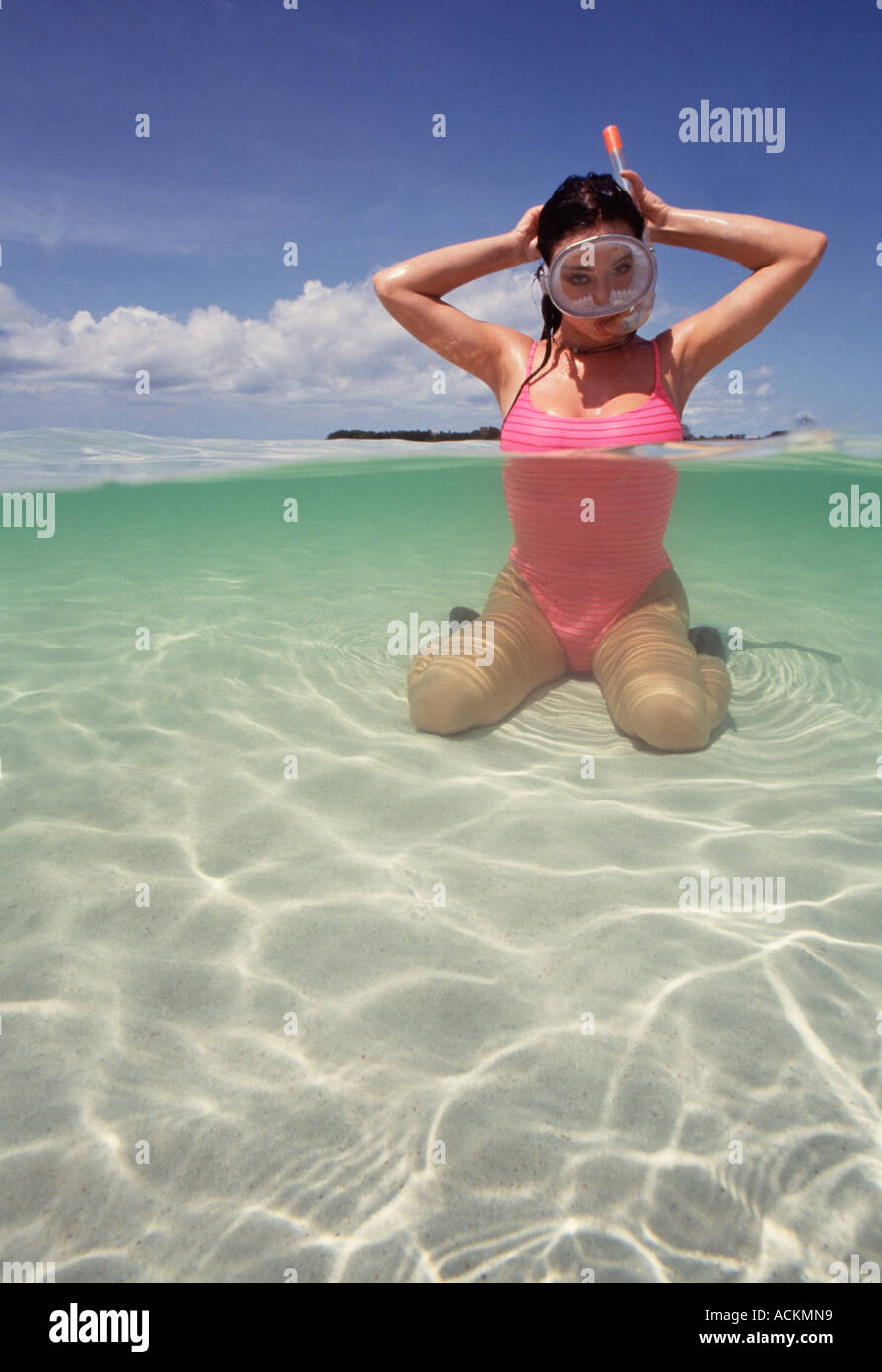 Unter über Frau kniend im flachen Wasser unter Wasser in rosa ein Badeanzug mit Schnorchel Tauchmaske Stockfoto